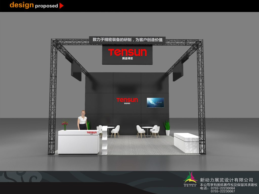 Exhibition booth design from the front, featuring a large black wall with a screen, a white reception desk with a mannequin, and a seating area.