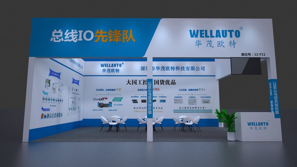 Front view of a white and blue trade show booth with seating, a reception desk, and informational displays.
