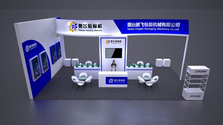 An aerial view of a white and blue trade show booth. It features a central counter with a monitor and attendant, two seating areas, and several wall displays.