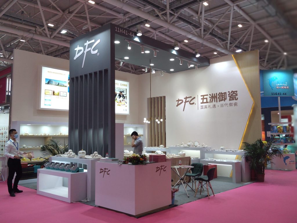 Another view of the busy booth displaying ceramics and staff.