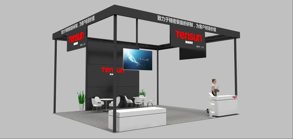 A 3D rendering of a modern exhibition booth design with black frames, a large screen, white seating, and a reception counter.