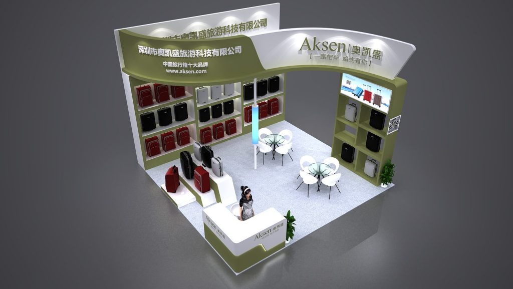 A 3D render of a green and white trade show booth filled with suitcases on display. A woman stands at the reception desk, with two round seating areas.