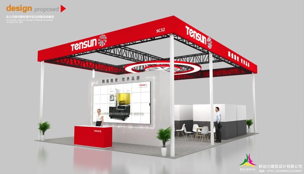 A 3D render of an exhibition booth design showing a large screen with yellow industrial machinery, a red counter, and a small seating area.