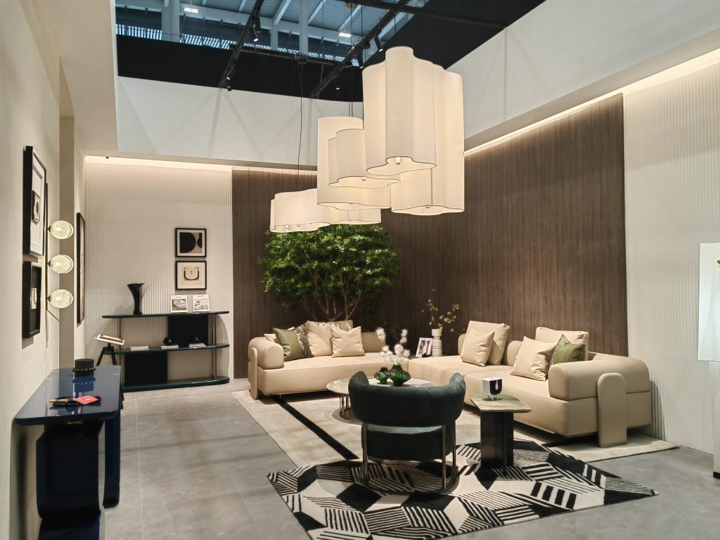 Contemporary living room with a large beige L-shaped sofa, dark green accent chair, and three large white rectangular ceiling lights.Contemporary living room with a large beige L-shaped sofa, dark green accent chair, and three large white rectangular ceiling lights.