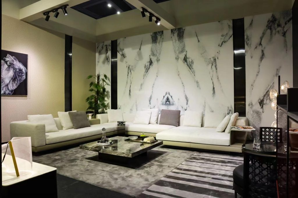 Modern living room: white sofas, marble table, abstract marble wall.