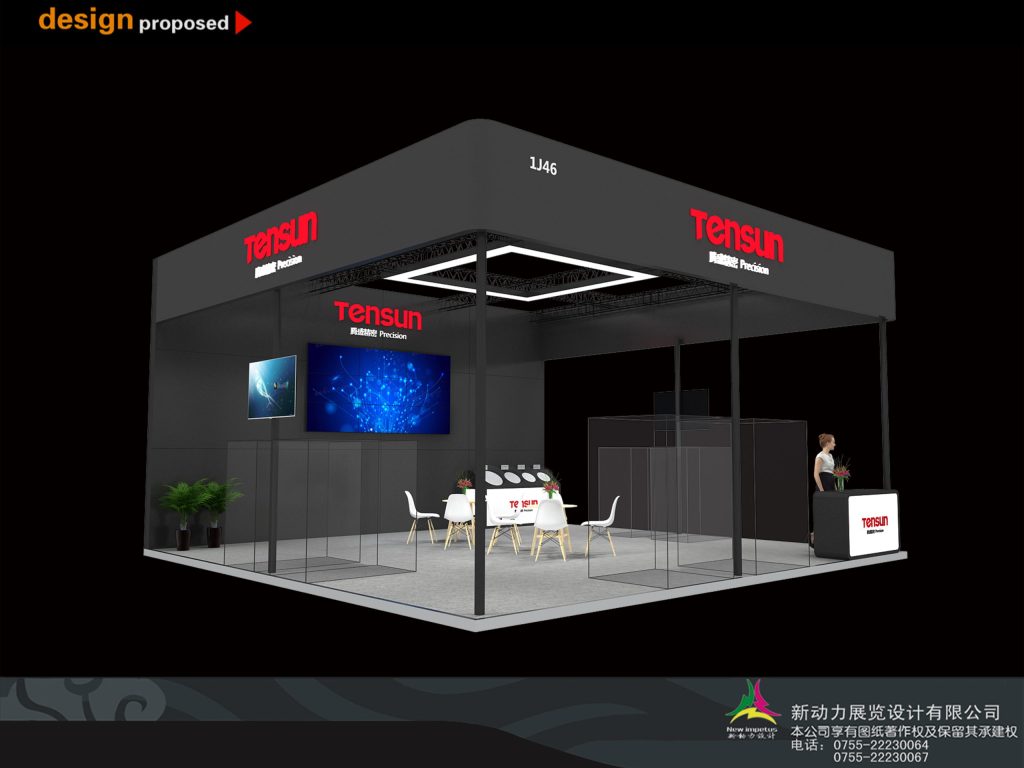 Modern black exhibition booth featuring a central seating area, large screens with blue patterns, and a reception counter.