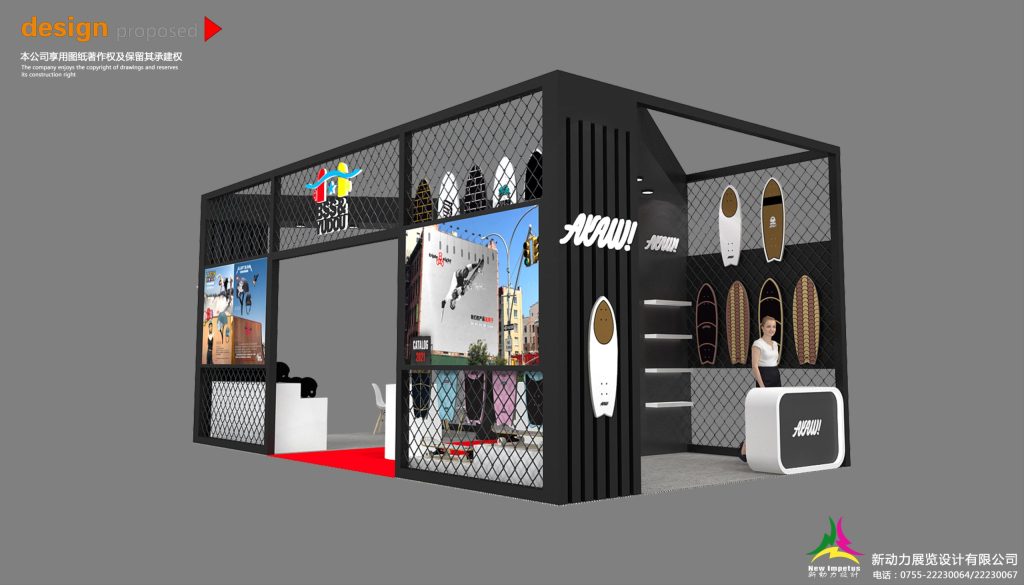 Exterior view of a black mesh trade show booth showcasing surfboards, graphic displays, a reception desk, and a mannequin.