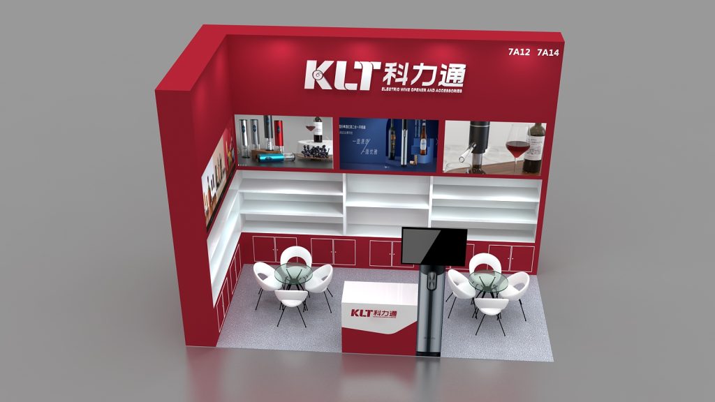 Angled overhead view of a red and white exhibition booth, showing product images, a central monitor, empty white shelves, and two white seating areas.