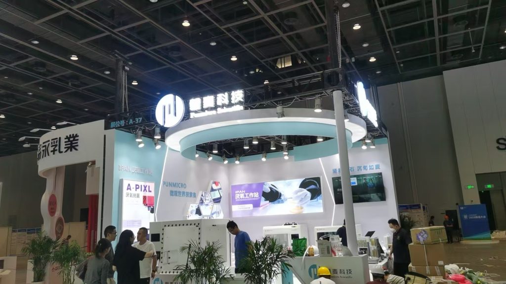 Setting up an exhibition booth with bright displays in a large hall.