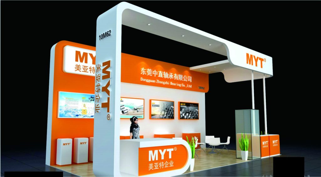Angled view of a vibrant orange and white exhibition booth with a person working.