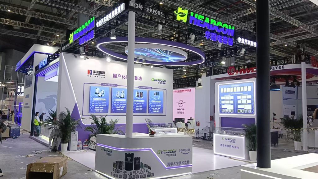Exhibition booth, purple and white, with illuminated displays.