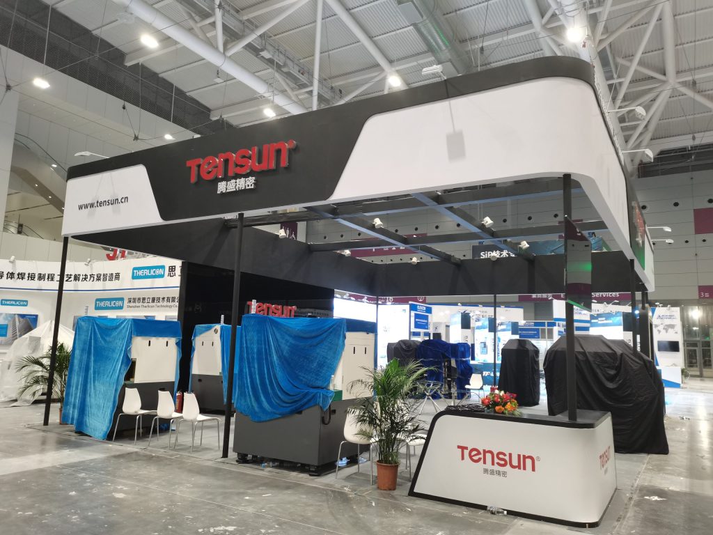 Exhibition booth setup: covered machinery, reception.
