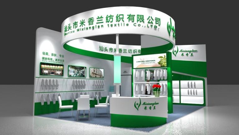 3D render of a green and white exhibition booth displaying hanging and folded white shirts, a reception desk with flowers, and a meeting table.