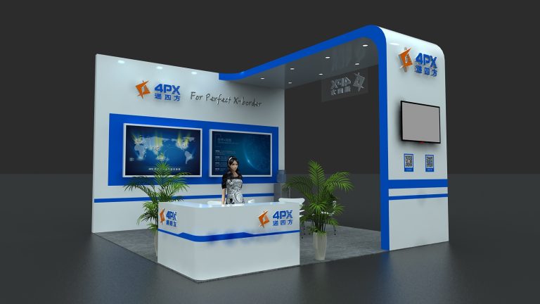A person stands behind a white and blue reception desk at an exhibition booth. Two large screens display maps, a side screen and plants are also visible.