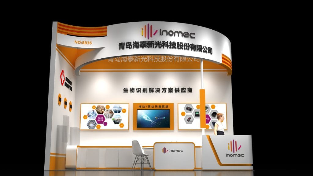 Render of a sleek white and orange exhibition booth with three display screens and a large monitor, next to a reception desk with a chair.