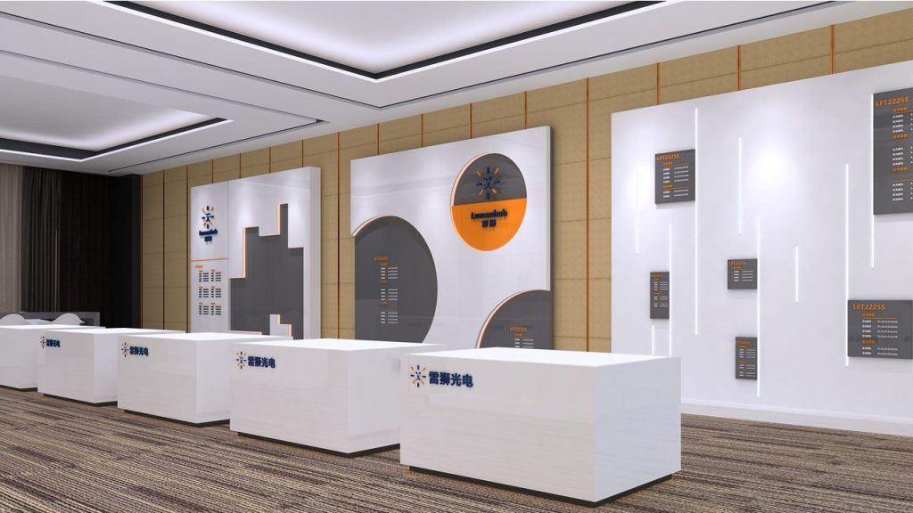 A digital rendering of an exhibit booth with white display counters, dark grey and white walls with circular graphics, and a patterned carpet.