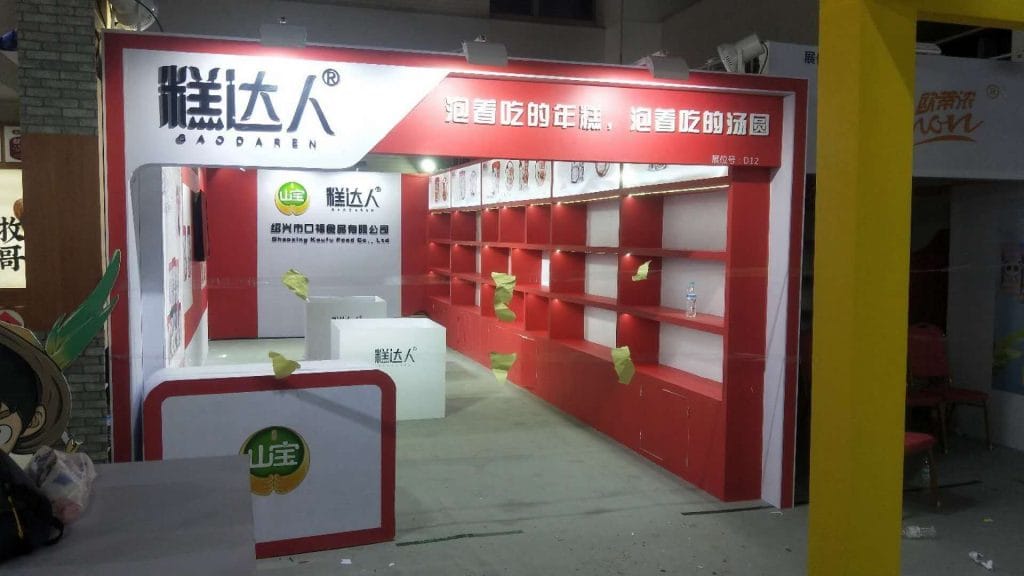 Empty red and white exhibition booth with prominent shelving.