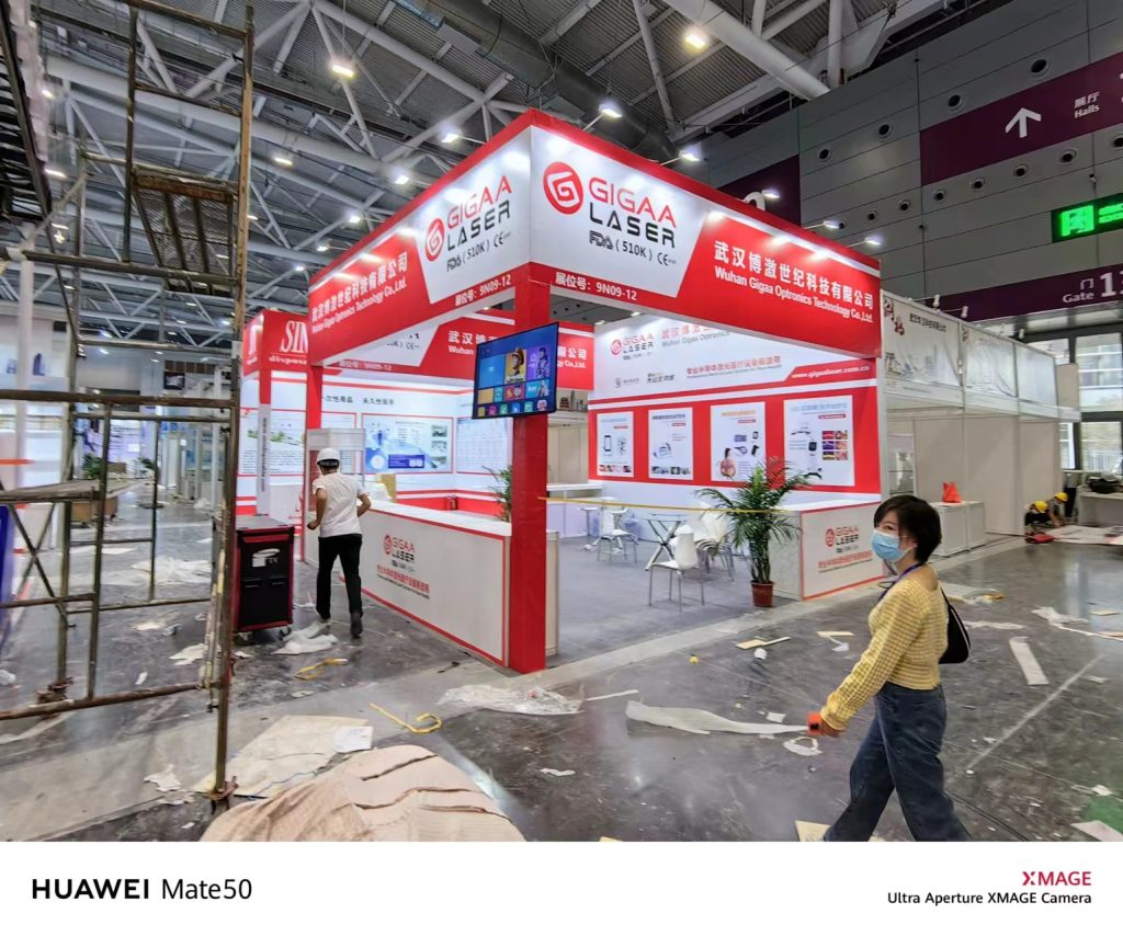 Partially assembled booth with a person walking past debris-strewn floor.