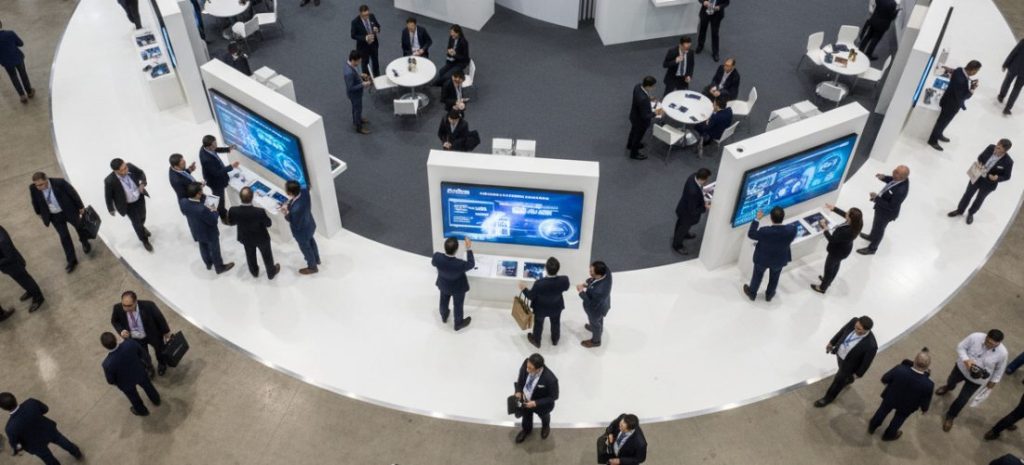 Trade show booth featuring interactive screens and tablets for visitors, people engaging with touchscreens, modern technology, professional exhibition hall, high-detail, realistic business environment, bright lighting