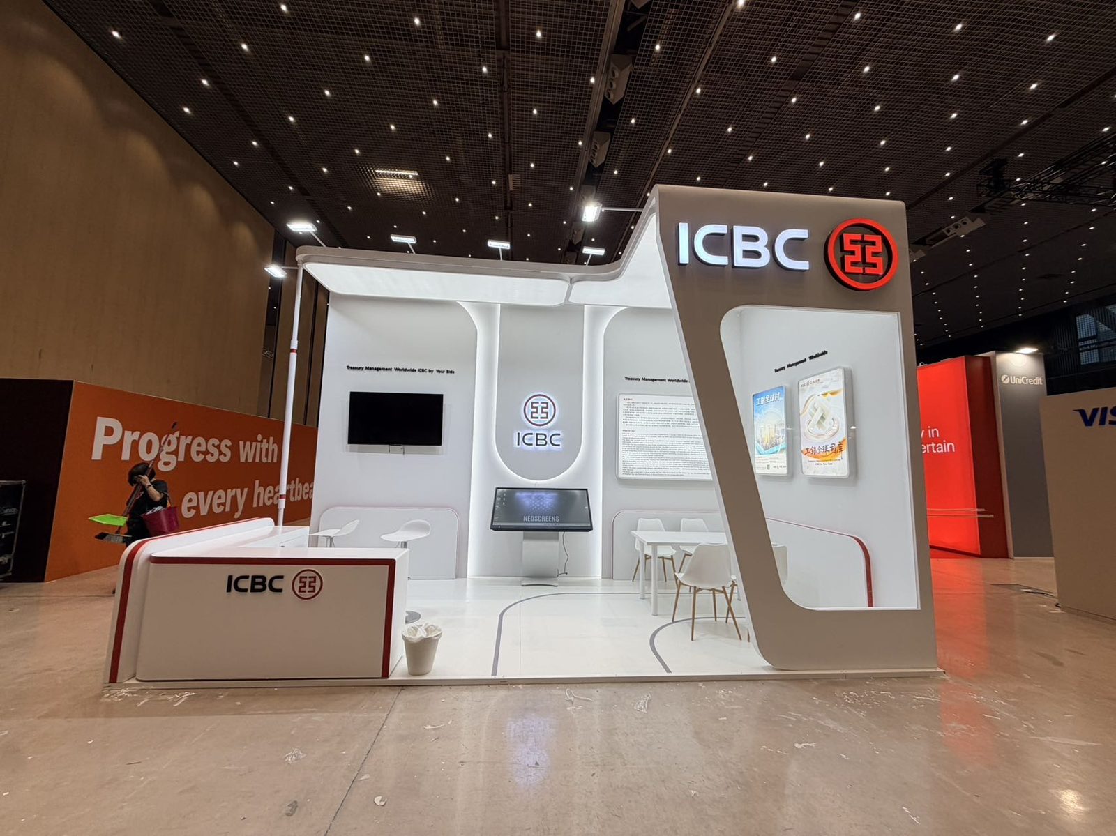 white custom exhibition stand with backlit logo tower at a trade show in Spain